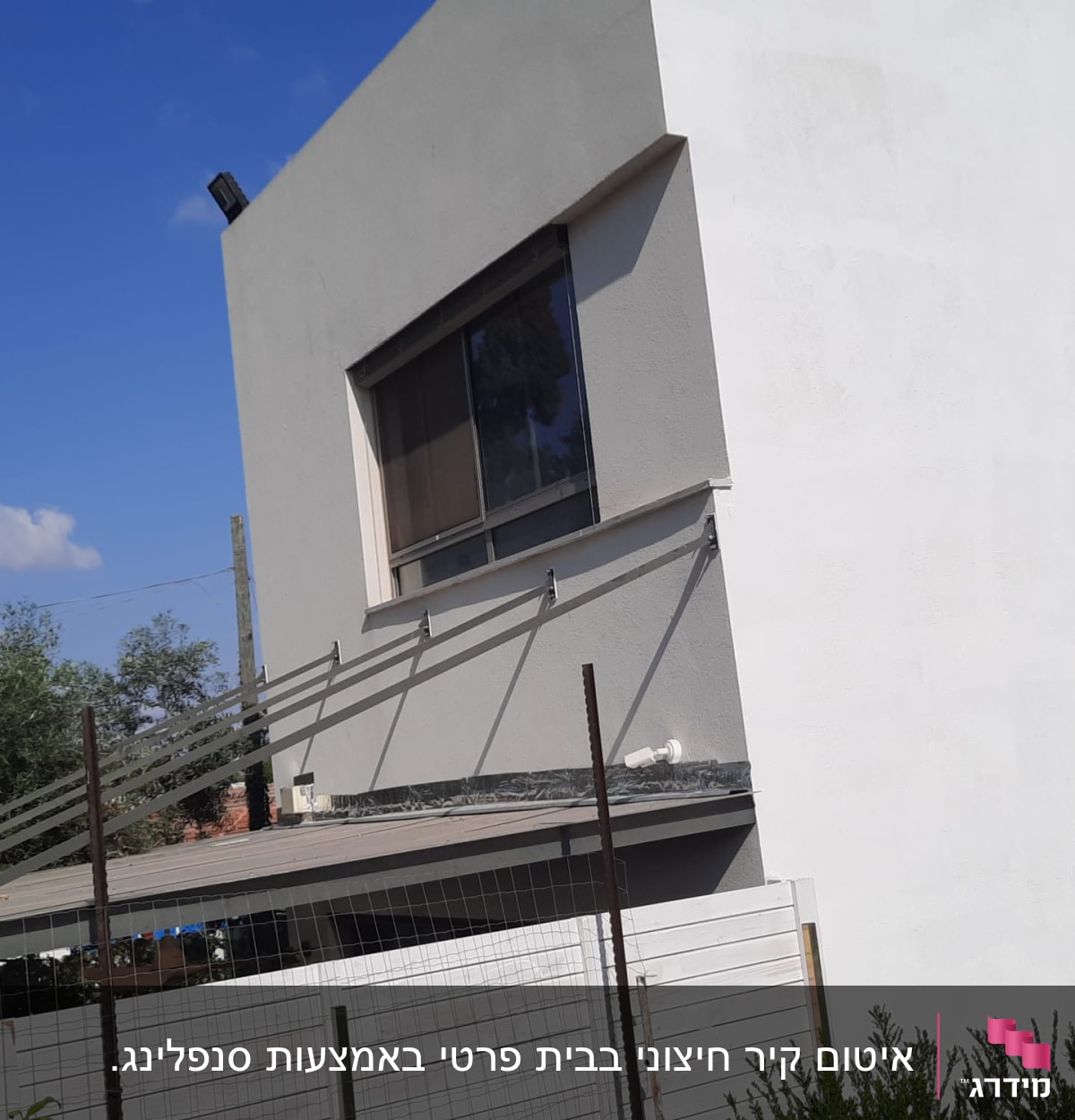 קיר חיצוני עם חלון וגג קטן מתחתיו